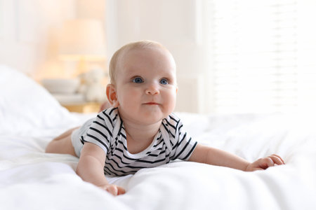 Cute little baby on bed at home