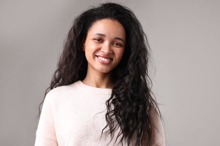 Portrait of beautiful young woman on light gray background