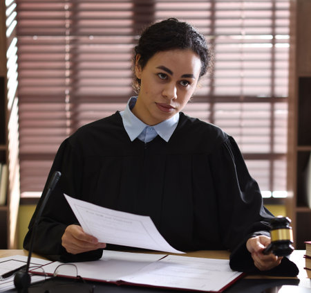 Judge in court dress working at desk indoors, selective focus