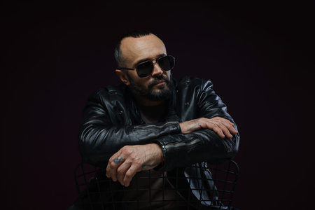Fashion model. Handsome man in sunglasses on black background