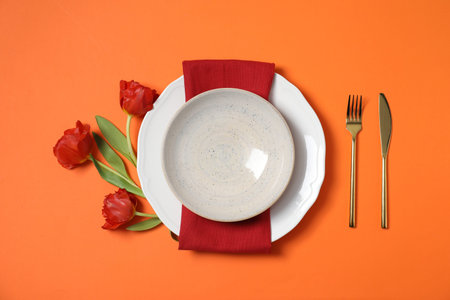Beautiful table setting on orange background, flat lay