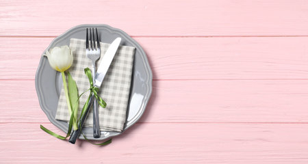 Stylish table setting with floral decor on pink wooden background, top view. Space for text