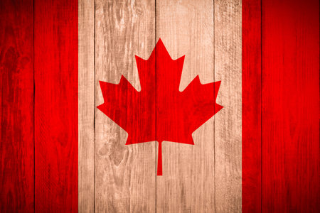 Flag of Canada with maple leaf on wooden surface as backgroundの写真素材