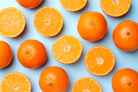 Fresh ripe tangerines on light blue background, flat lay