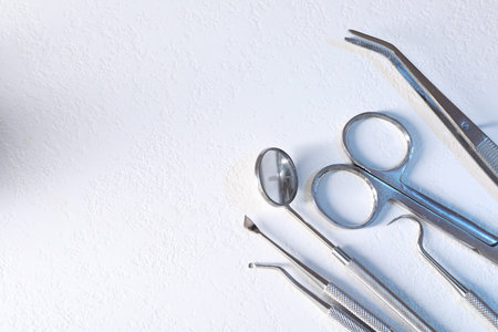 Many different dental instruments on white table, flat lay. Space for text