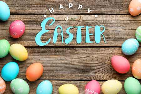 Happy Easter greeting card or poster with colorful eggs on wooden background, top view