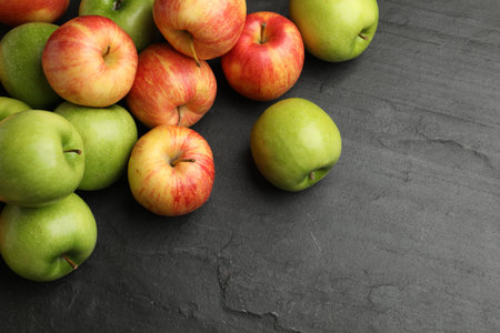 Fresh ripe apples on gray textured table, space for text