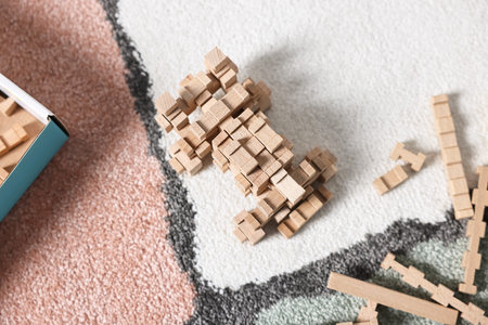 Figure made of wooden blocks on floor, top view