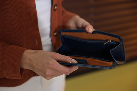 Poverty. Woman with empty wallet indoors, closeup