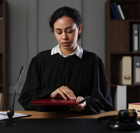 Judge with folder of documents at desk indoors