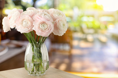 Bouquet of flowers in vase on table indoors. Space for text