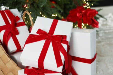 Beautiful wrapped gifts under Christmas tree at home, closeup