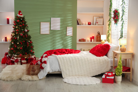 Beautiful Christmas decor and comfortable bed in bedroom. Interior designの写真素材