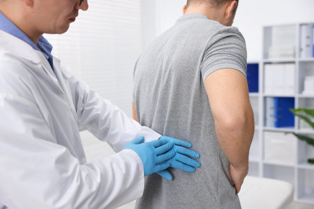 Doctor in medical gloves examining patient in clinic, closeup