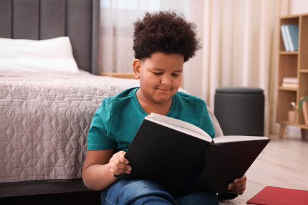 Boy reading book on floor at home