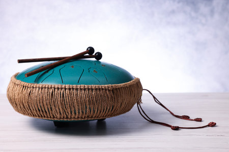 Steel tongue drum and mallets on light wooden table, closeupの写真素材
