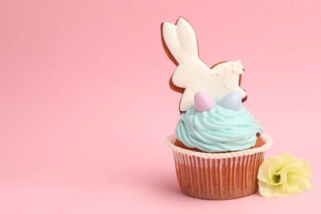 Tasty cupcake with Easter decor on pink background, closeup. Space for text
