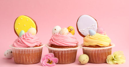 Tasty cupcakes with Easter decor on pink background, closeup