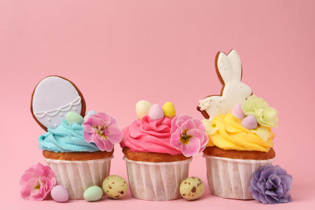 Tasty cupcakes with Easter decor on pink background, closeup