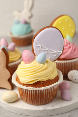 Tasty cupcakes with Easter decor on gray table, closeup