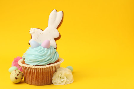 Tasty cupcake with Easter decor on orange background, closeup. Space for text