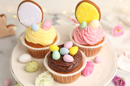 Tasty cupcakes with Easter decor on white marble table, closeup