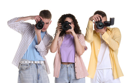 Group of photographers taking pictures with professional cameras against white background