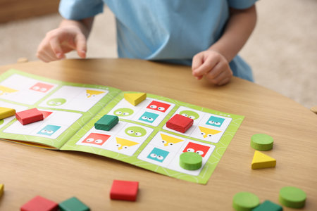 Little boy playing with educational toys at wooden table indoors, selective focusの写真素材