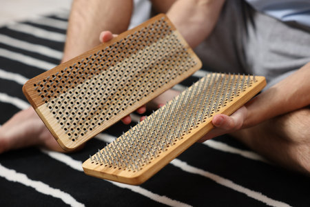 Man with boards sitting on floor at home, closeup