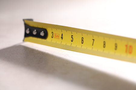 One measuring tape on grey table, closeup
