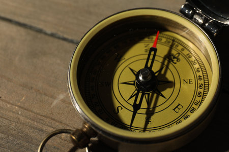One vintage compass on wooden table, closeup