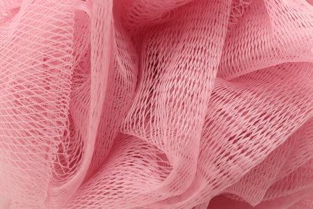 Pink mesh sponge as background, closeup. Shower accessoryの写真素材