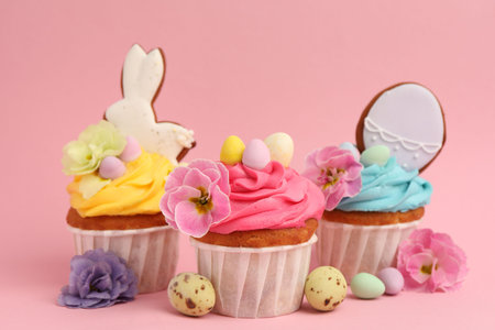 Tasty cupcakes with Easter decor on pink background, closeup