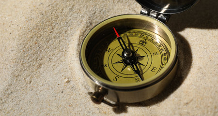 One vintage compass on sand, closeup view