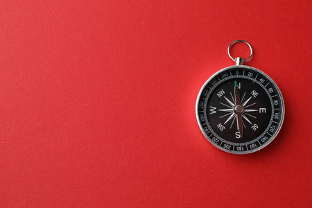 One compass on red background, top view. Space for text