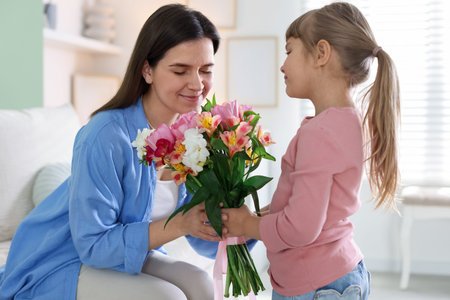 Happy Mother's Day. Little girl greeting her mom with bouquet of beautiful flowers at home