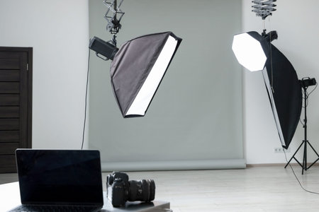 Professional lighting equipment hanging from ceiling in photo studioの写真素材