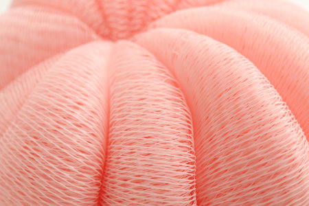 Pink mesh sponge as background, closeup. Shower accessoryの写真素材