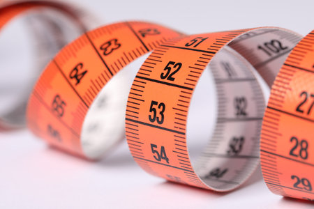 One measuring tape on white background, closeup