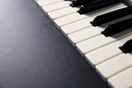 Piano keys on black background, closeup. Space for text