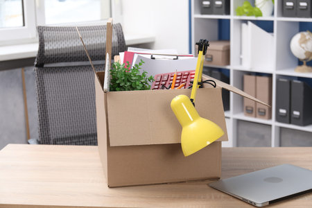 Dismissal. Box of personal belongings on desk in office