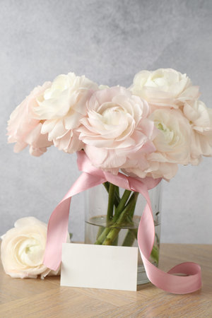 Beautiful flowers and blank card on wooden table