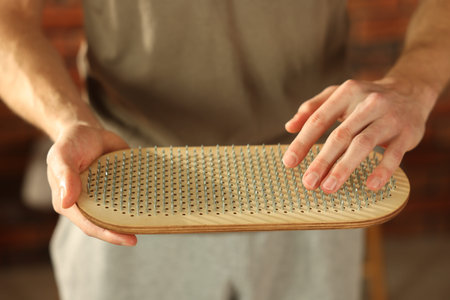 Man with sadhu board indoors, closeup view