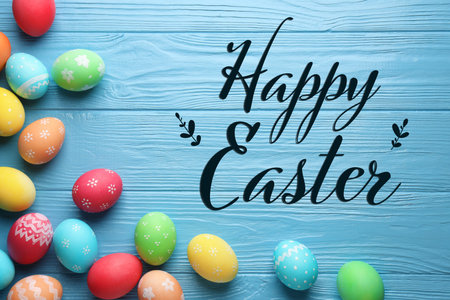 Happy Easter greeting card or poster with colorful eggs on blue wooden background, top view