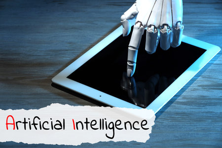 Robot using tablet computer. Text Artificial Intelligence on torn paper
