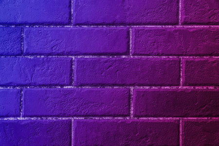 Neon lights on brick wall. Color gradient from magenta to blueの写真素材
