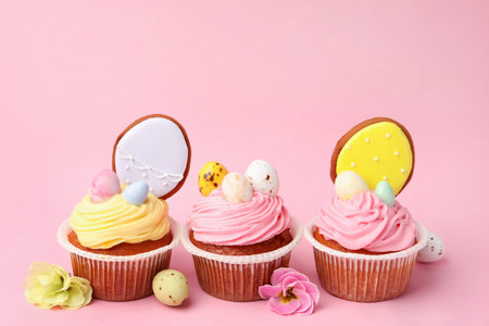 Tasty cupcakes with Easter decor on pink background, closeup