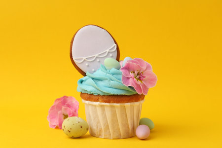 Tasty cupcake with Easter decor on orange background, closeup