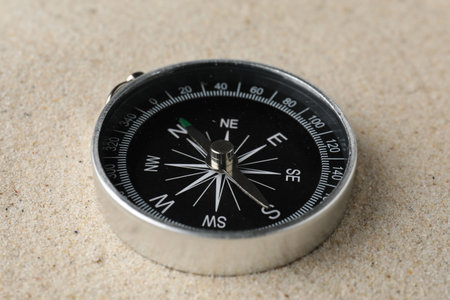 One modern compass on sand, closeup viewの写真素材