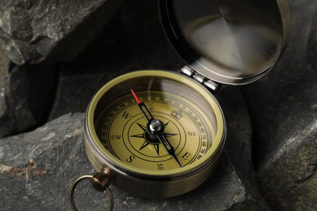 One vintage compass on stones, closeup view
